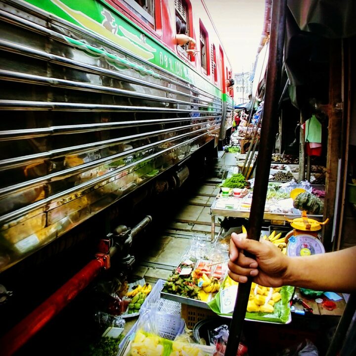 Train going through a market in Thailand. Thailand as a travel destination for families